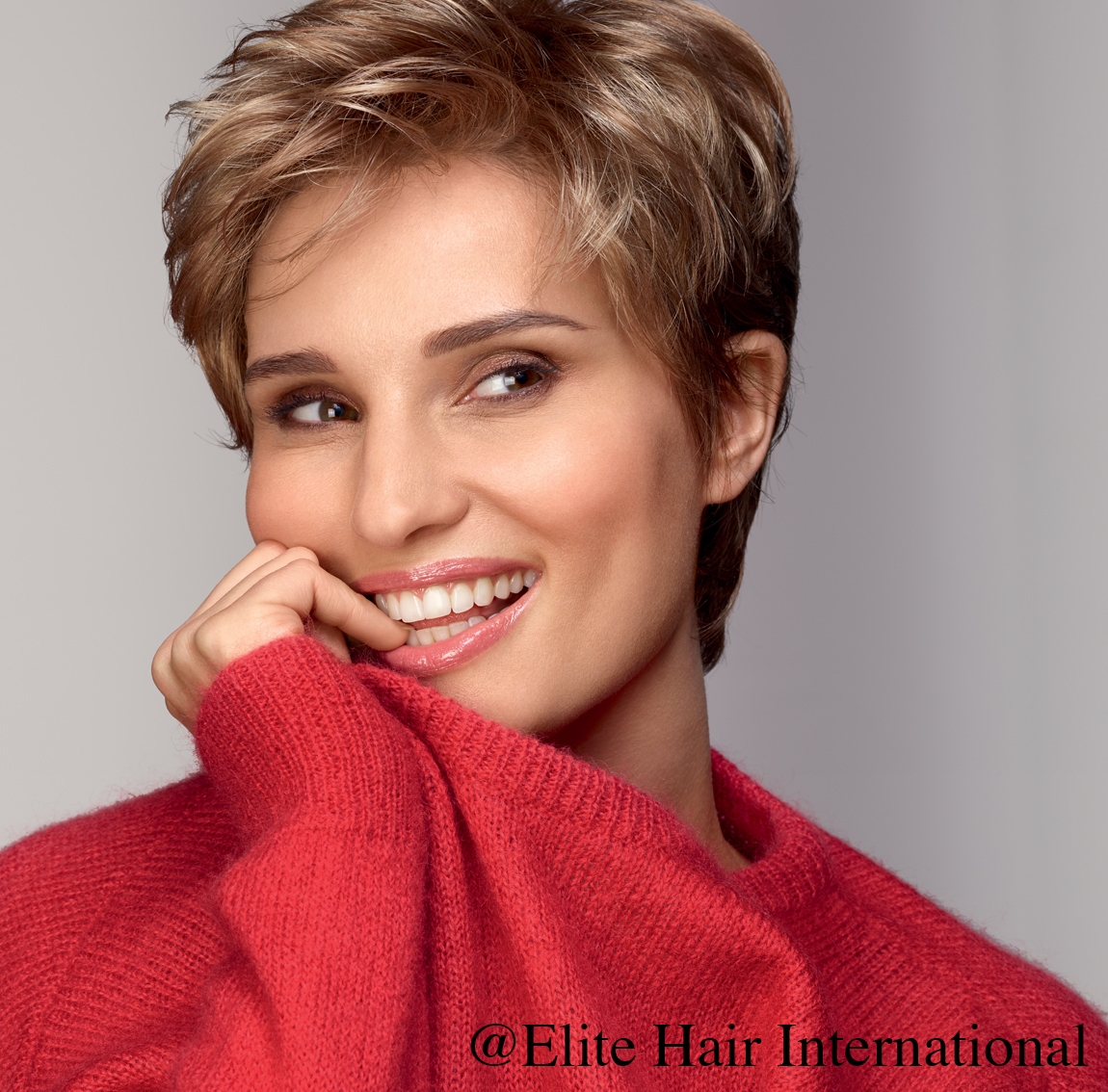 Portrait d'une femme portant la perruque Intense R ** en blond, cheveux de synthèse d'Elite Hair International