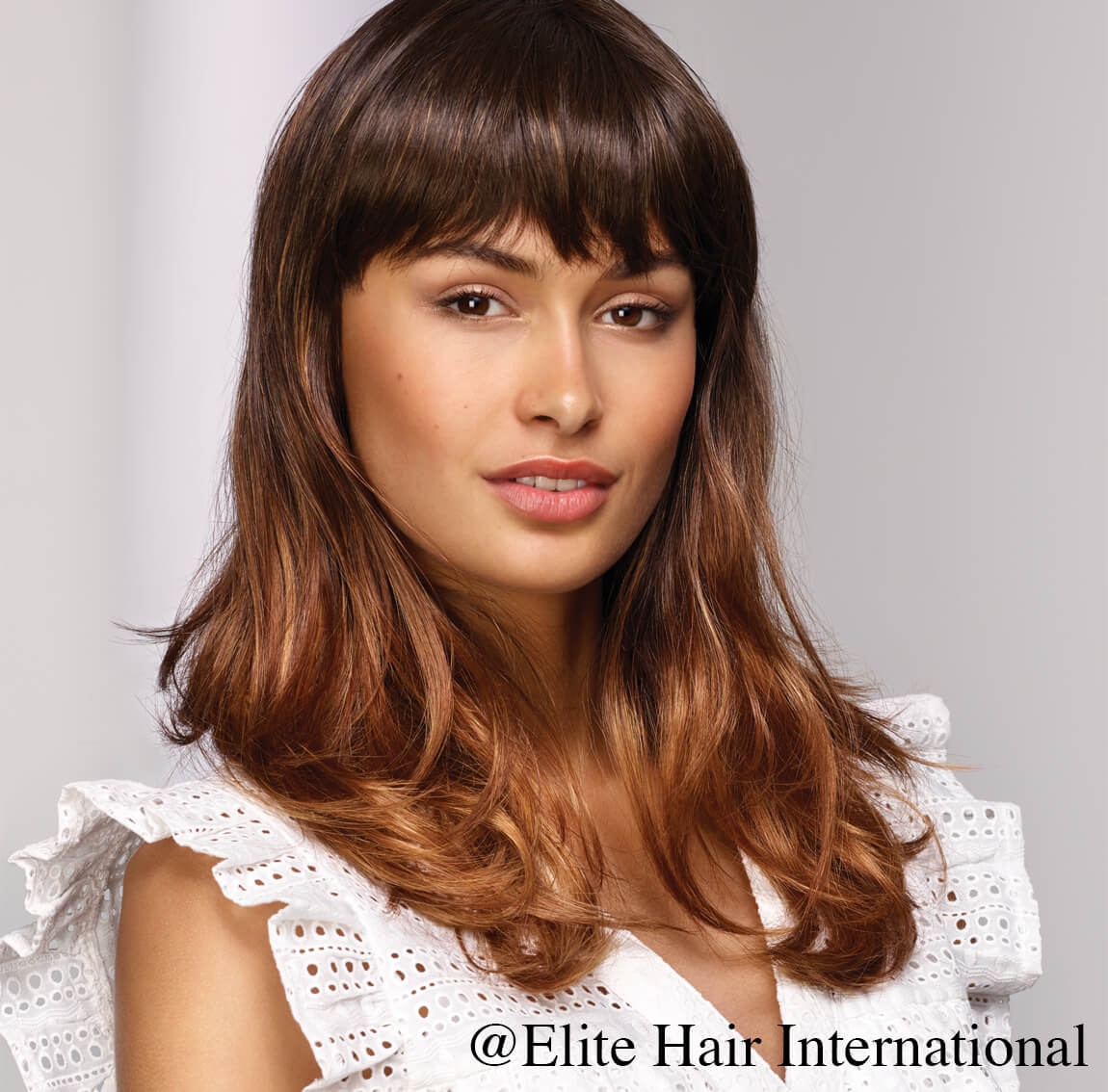 Portrait d'une femme portant la perruque Captive en cheveux de synthèse d'Elite Hair International